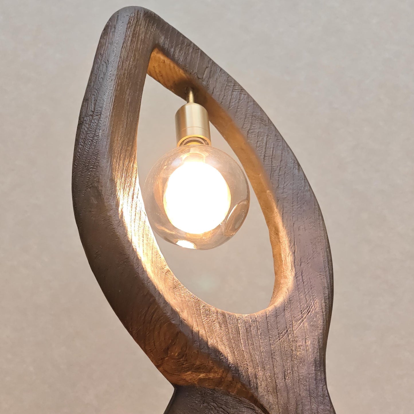 Wooden lamp with a light bulb inside on a beige background