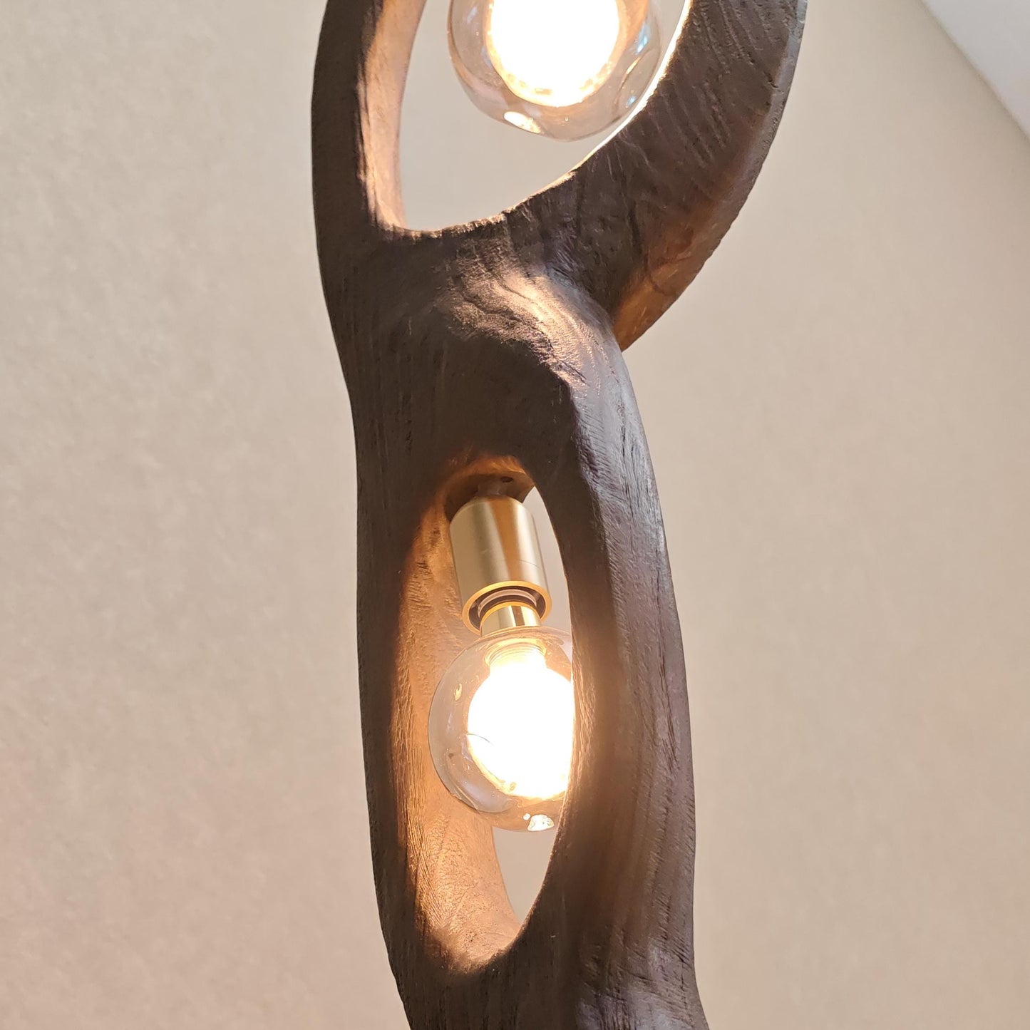 Wooden lamp with two light bulbs on a plain background
