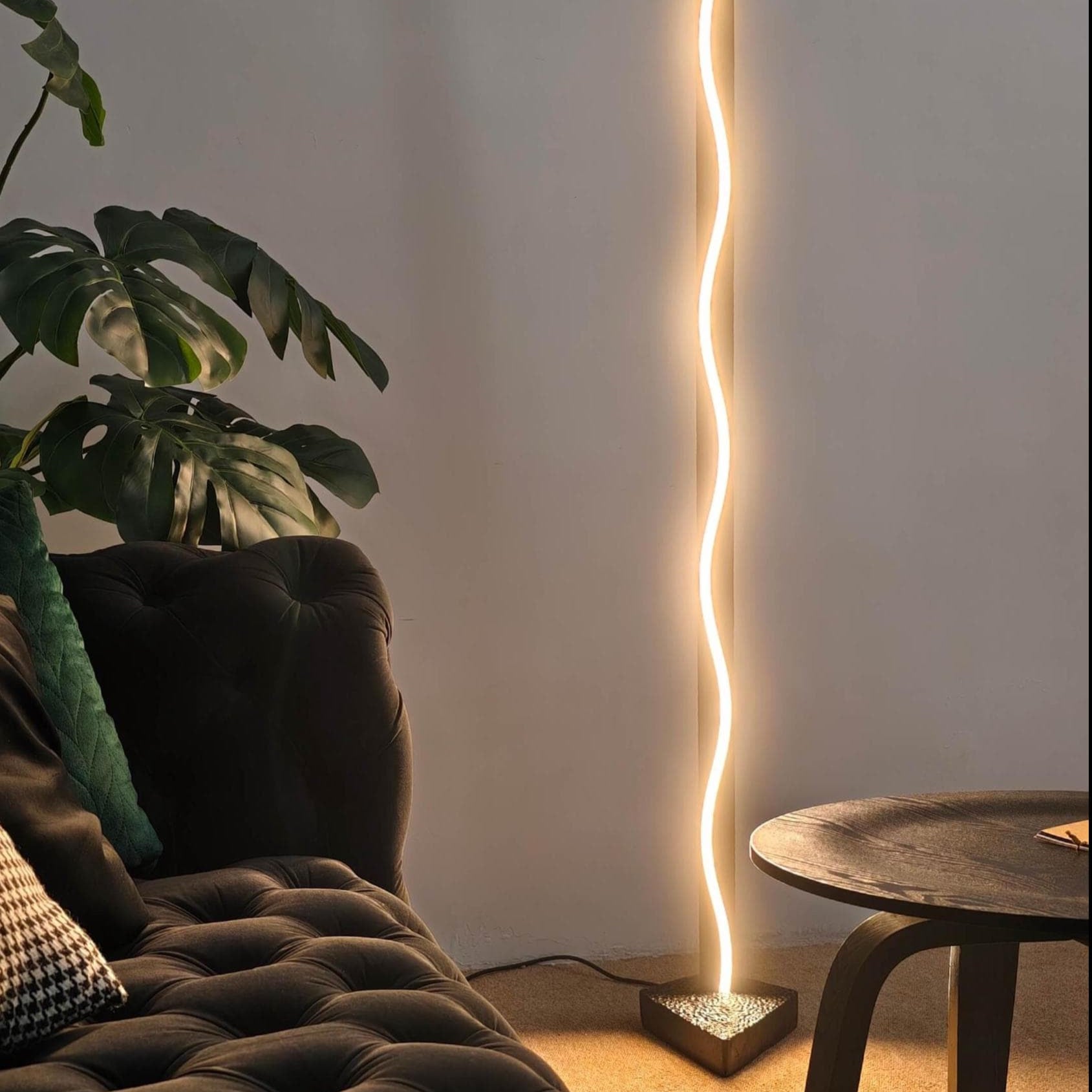 Modern floor lamp with a curved light design in a living room setting.